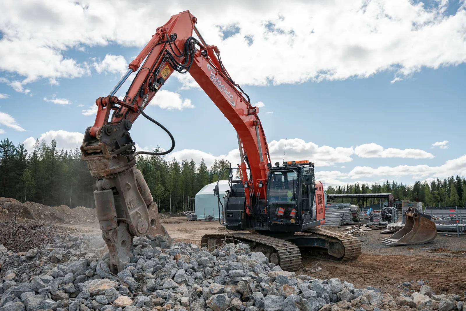 Grävmaskin river och sorterar massor på etableringsyta i Boliden