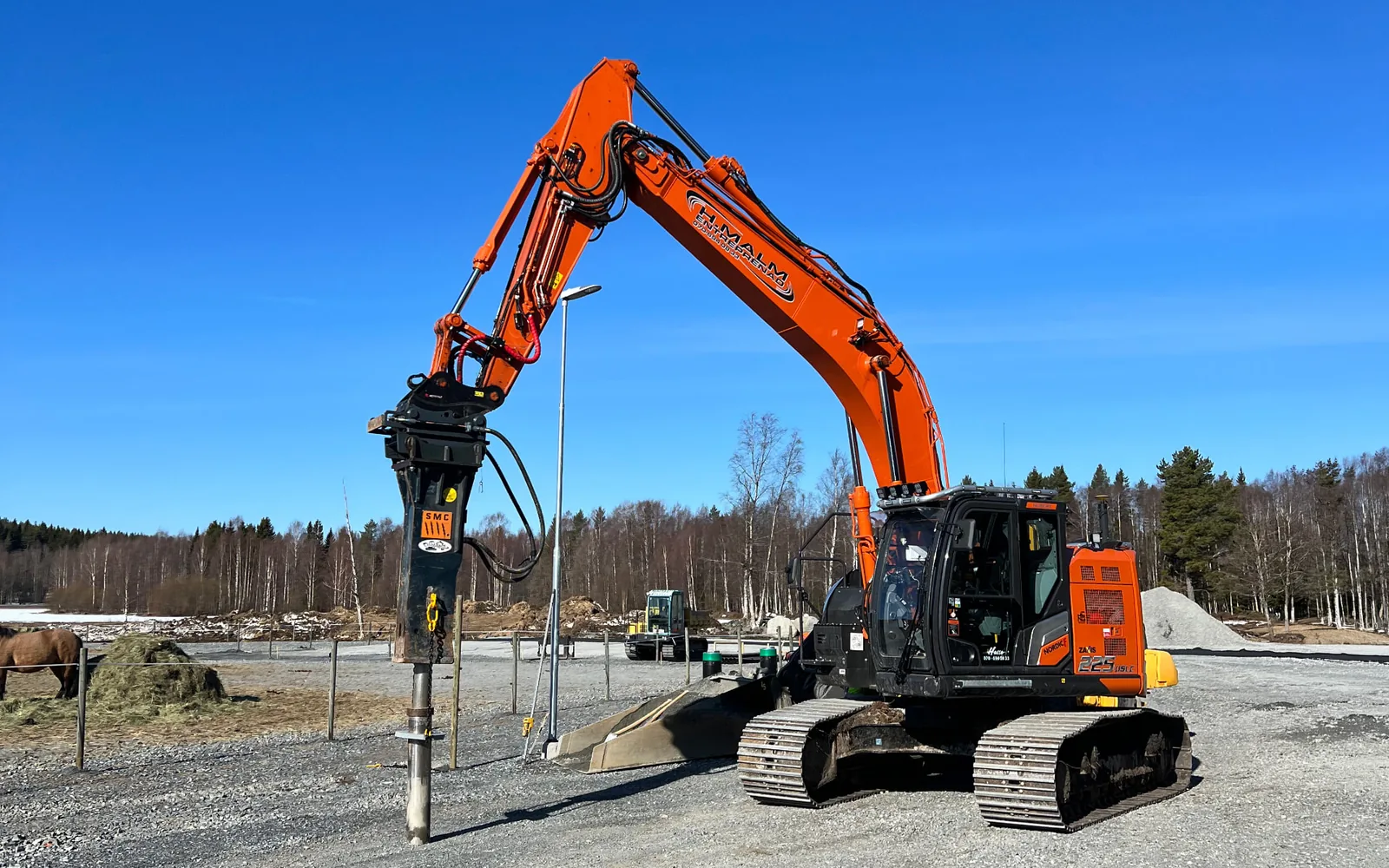 Grävmaskin med hydraulhammare utför bergspräckning i Skellefteå